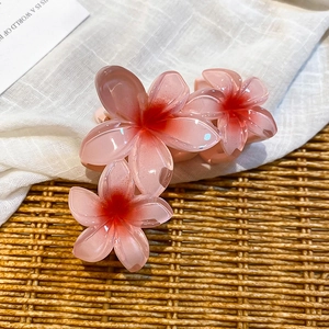 Detailed close-up of a three-flower acrylic hair claw clip with pink gradient petals