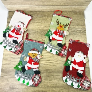 Detailed view of four burlap Christmas stockings with plush Santa and reindeer figurines