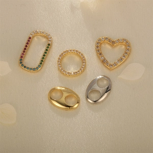Assorted 18K gold and silver plated jewelry pendants with zircons on satin background