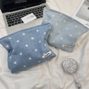 Close-up of denim cosmetic bags with white star patterns and secure zipper closure