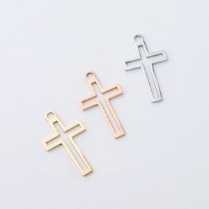 Detailed view of hollow cross pendants in silver, gold, and rose gold stainless steel
