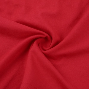 Nahaufnahme von rotem Strickstoff mit eleganten Spiral-Plissee-Details und weichem Griff
