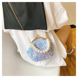 Close-up of blue sequin mini shell bag with elegant pearl handle and gold chain strap