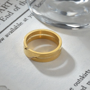 Vista macro di anello in acciaio inossidabile dorato con design sovrapposto su carta