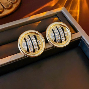 Detailed view of gold round leopard print earrings with rhinestones in a jewelry box