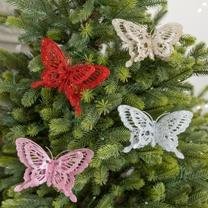 Glittering butterfly ornaments in red gold silver and pink on a green Christmas tree
