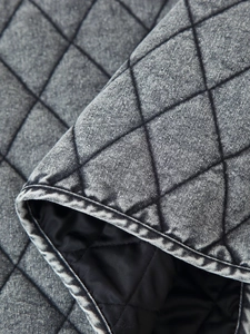 Detailed macro view of gray washed denim quilted fabric with classic diamond pattern