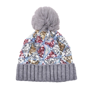 Dettaglio del cappello in maglia con paillettes colorate, pompon grigio e bordo a coste