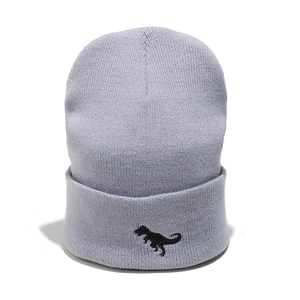 Close-up of a light purple knitted beanie featuring a black dinosaur embroidery
