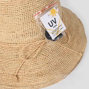 Detail of UV protection tag and elegant ribbon bow on straw sun hat for women