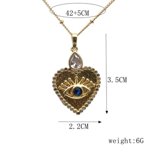 Detail of gold heart pendant with evil eye design and dimensions 3.5cm x 2.2cm