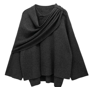 Detail of dark grey asymmetrical knit cardigan with button and pleat texture