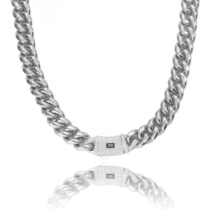 Macro detail of silver-tone stainless steel curb chain with iced out zircon spring clasp