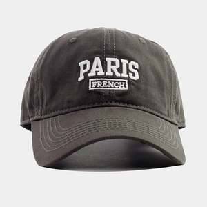 Close-up of white Paris embroidery on dark grey cotton twill baseball cap fabric