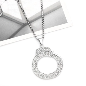 Macro shot of silver handcuff pendant with sparkling crystals on a square link chain