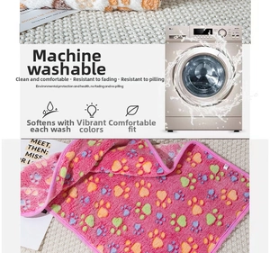 Detail of pink fleece pet blanket showing colorful paw prints and machine washable texture