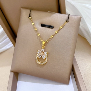 Elegant gold titanium steel necklace with sparkling floral zirconia pendant on velvet base