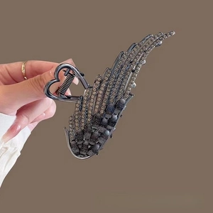 Close-up of angel wing hair claw with cat eye stones and heart-shaped handle detail