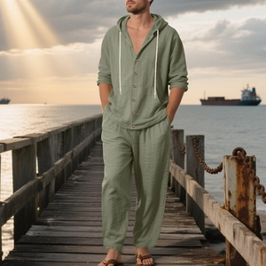 Detail of sage green men's linen beach set featuring a hooded shirt and drawstring trousers
