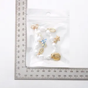 Detail of seashell pearl necklace with starfish charms and adjustable lobster clasp