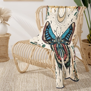 Detail of bohemian flannel blanket featuring colorful butterfly and moon with tassels
