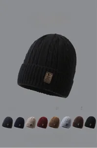 Winter knit beanie showing various trendy color options and premium leather brand label