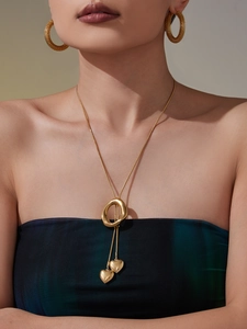 Detail showing gold heart pendants and mesh texture earrings on a model closeup