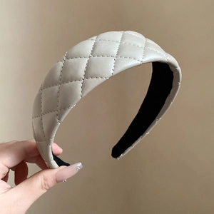 Beige faux leather headband with classic quilted diamond pattern and non-slip lining