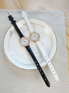 Close-up of small vintage women watches with diamond bezels in black and white leather