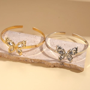 Detail of metallic butterfly cuff bracelet featuring sparkling rhinestones in gold and silver