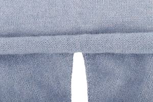 Macro view of light blue knitted hooded scarf showing soft texture and fine stitching