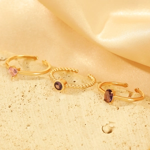 Detailed macro view of three golden adjustable rings with heart and oval zircon stones