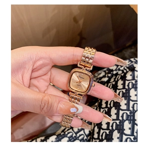 Close-up of elegant rose gold square quartz watch with stylish metal chain link strap