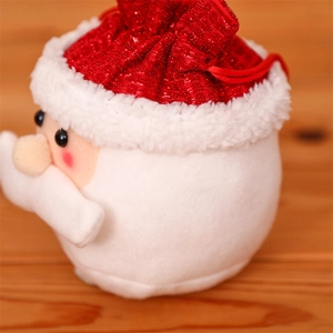 Close-up of Santa Claus plush drawstring gift bag with red sequins on wood background
