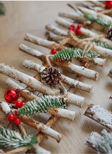 Detail of birch wood fence with pine cones, red berries and artificial snow texture