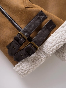 Detail of brown leather strap and buckle on warm faux sheepskin fleece vest