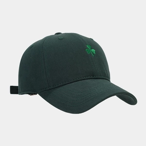 Close-up of green clover embroidery on dark green cotton canvas baseball cap