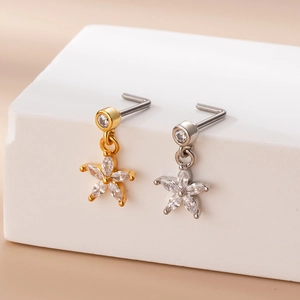 Detailed macro view of gold and silver nose studs with micro-pave zircon star pendants