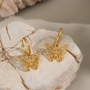 Elegant gold butterfly hoop earrings made of stainless steel on natural stone surface
