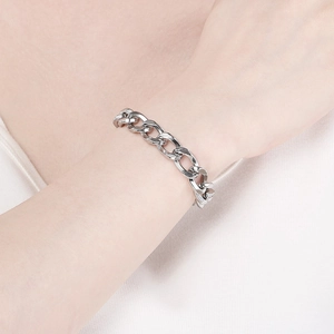 Detail shot of a silver Cuban chain link bracelet in titanium steel worn on a wrist