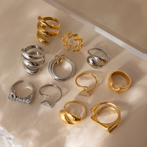 Nahaufnahme verschiedener Edelstahlringe in Gold und Silber mit geometrischen Designs