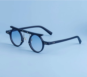 Detail of matte black sunglasses with blue gradient lenses and gold star studs