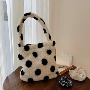 Gros plan du sac en polaire à pois noir et blanc avec étiquette sur table en bois
