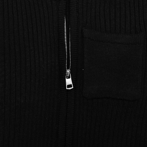 Close-up of black ribbed knit fabric with silver metal zipper and square patch pocket