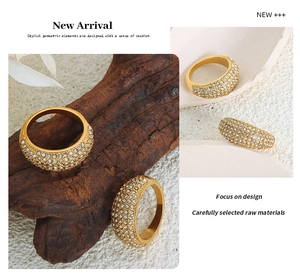 Macro detail of gold-plated chunky ring with full pavé-set crystals on a wooden base