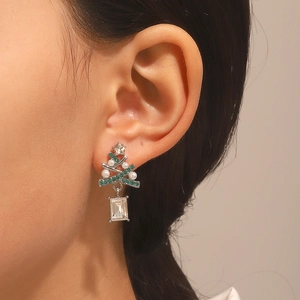 Detail view of Christmas tree earring with green zircon and rectangle crystal on model