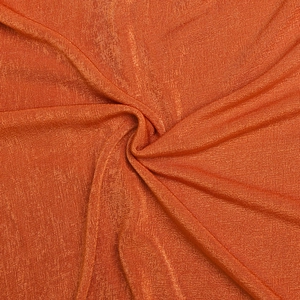 Gros plan sur un tissu en maille orange avec une texture subtilement scintillante