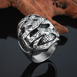 Close-up of rock hip-hop mummy skull ring made of polished stainless steel on wood