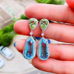 Detailed view of bicolor pear and emerald cut blue sea zircon earrings for bridal wedding
