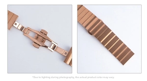 Detail of rose gold stainless steel watch band with butterfly clasp and brushed texture